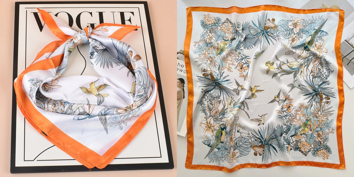 An orange and white silk scarf featuring a delicate floral print on a black background.