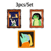 A set of three enamel brooches featuring a cat, a frog, and a blue-green creature.