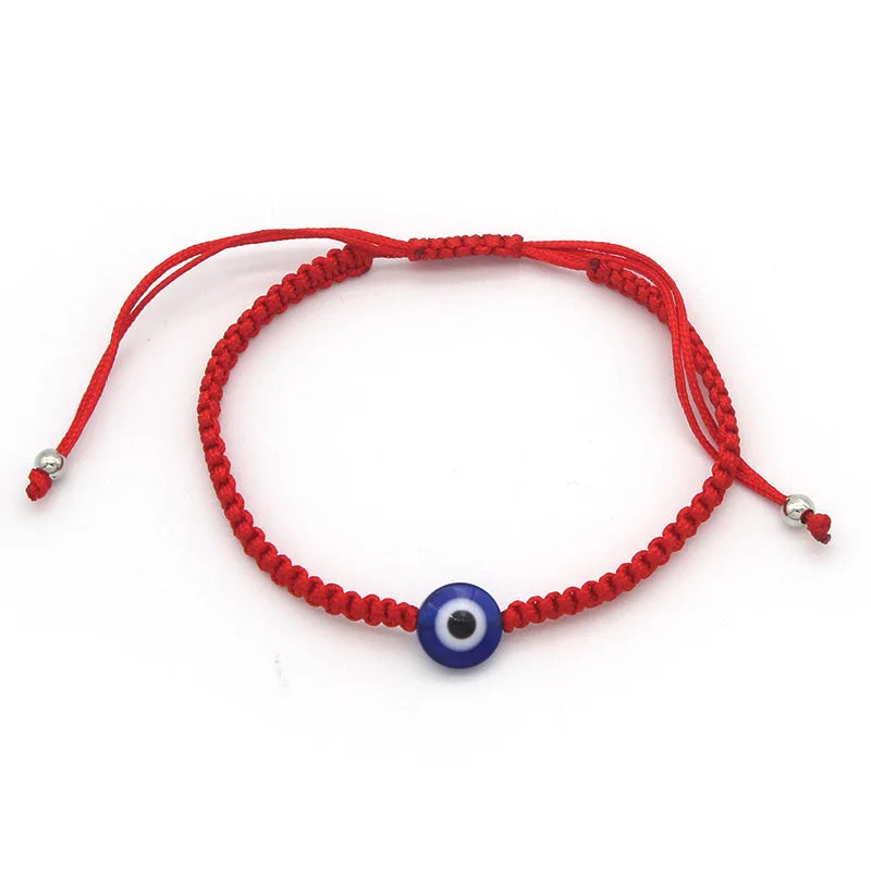 Red string bracelet with a blue evil eye charm for protection