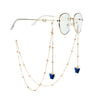 Gold chain necklace with butterfly pendants and round clear-tinted glasses.