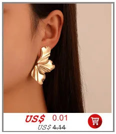 Gros plan d'un collier ras-de-cou imitation perles dorées porté à l'oreille d'une mannequin.