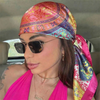 Eine Frau trägt einen rosa Seiden-Satinschleier-Hijab und Sonnenbrille drinnen.