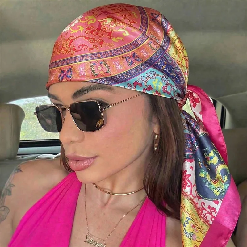 Eine Frau trägt einen rosa Seiden-Satinschleier-Hijab und Sonnenbrille drinnen.