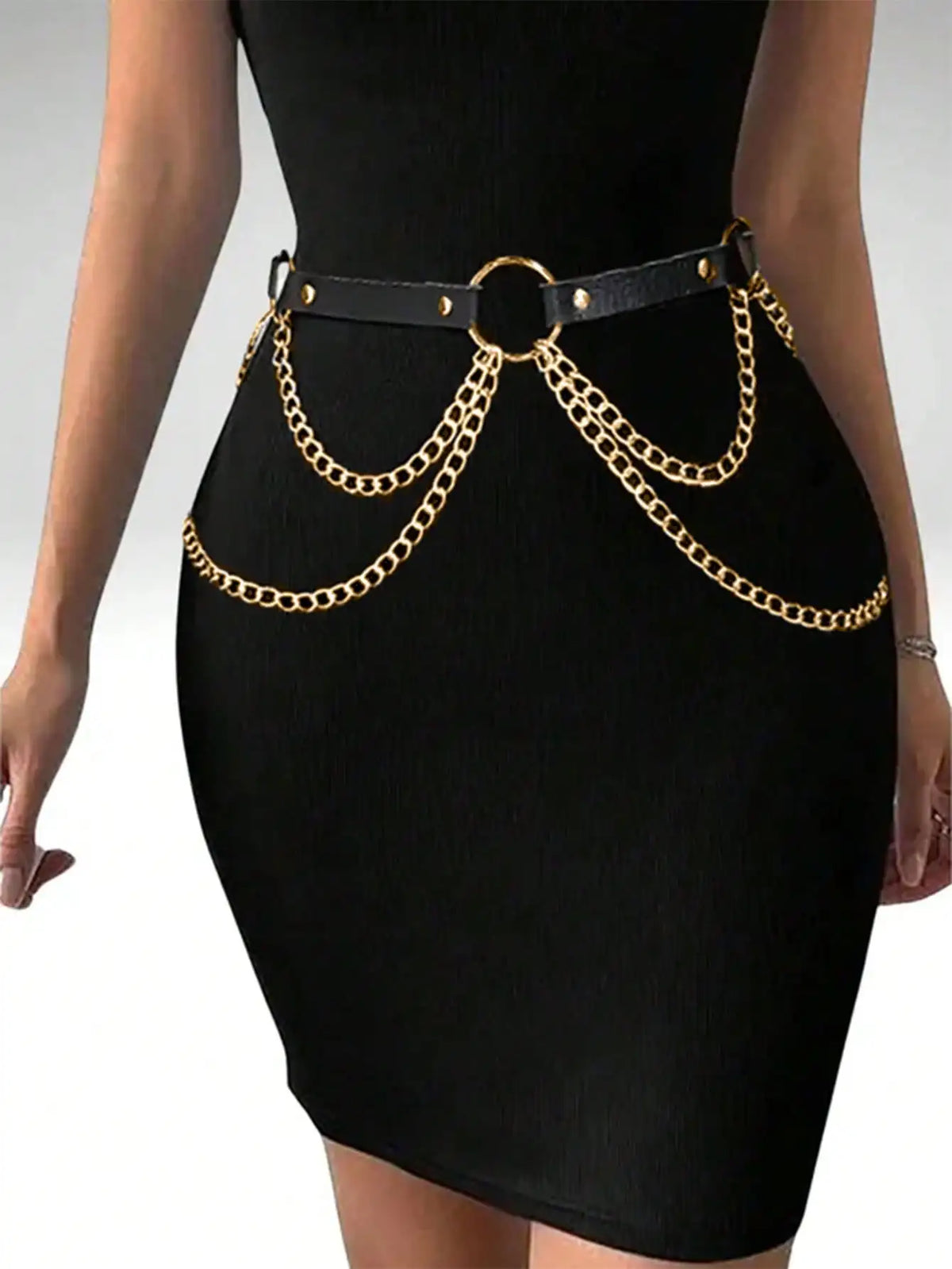 Un vestido negro ceñido con un cinturón de arnés de cadena dorada y hebilla circular.