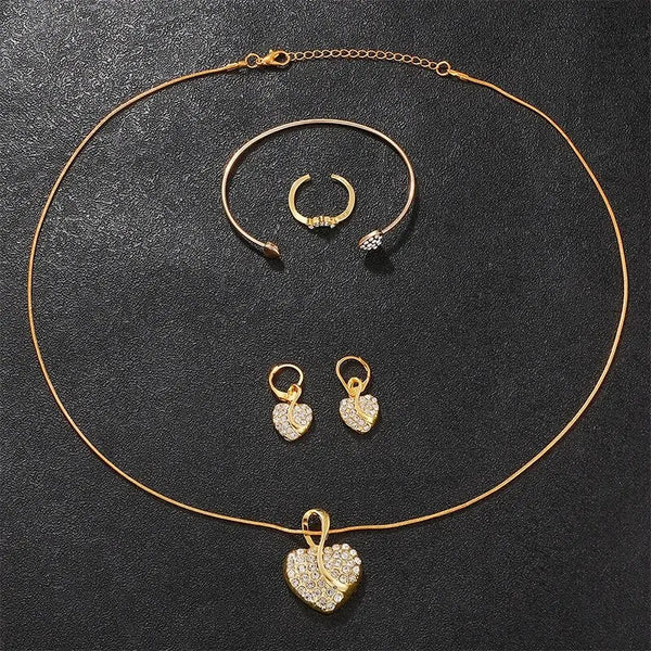A set of dainty gold-toned quartz jewelry including a watch, ring, necklace, and earrings displayed on a dark background.