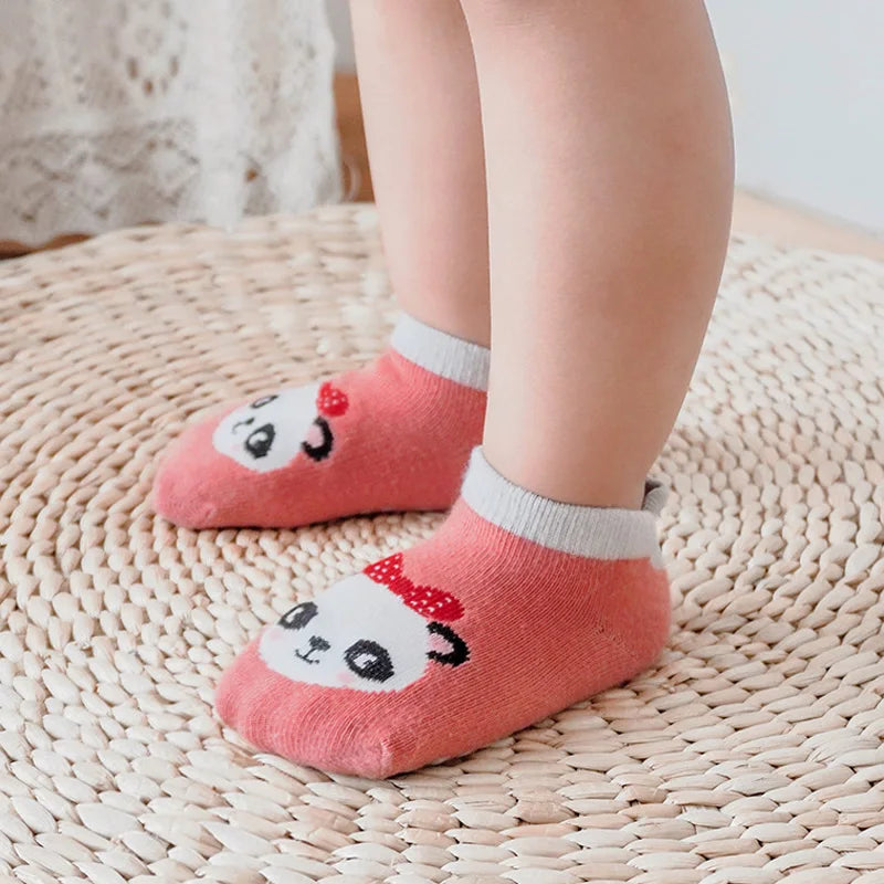 Rosa Baumwollsocken mit Panda-Gesichtmuster auf einem gewebten Matten.