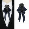 A dark blue luxury rhinestone bow tie neck tie displayed on a white shirt and black suit jacket.