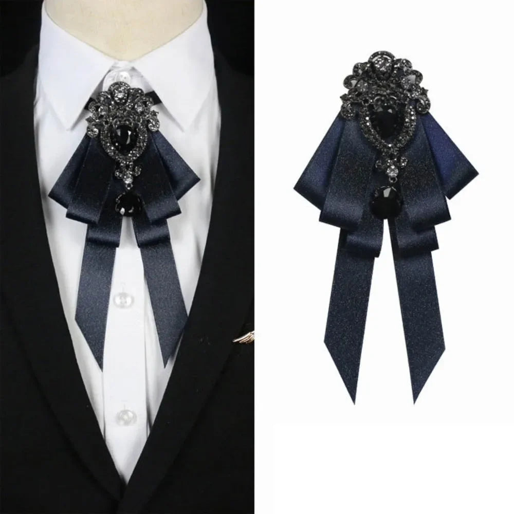 A dark blue luxury rhinestone bow tie neck tie displayed on a white shirt and black suit jacket.