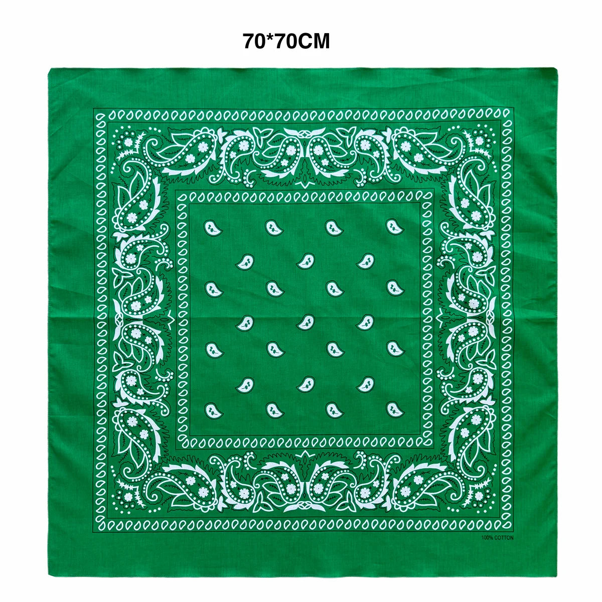 A green fabric square featuring white paisley and decorative borders.