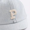 A light gray denim baseball cap featuring a stitched letter P on the front.