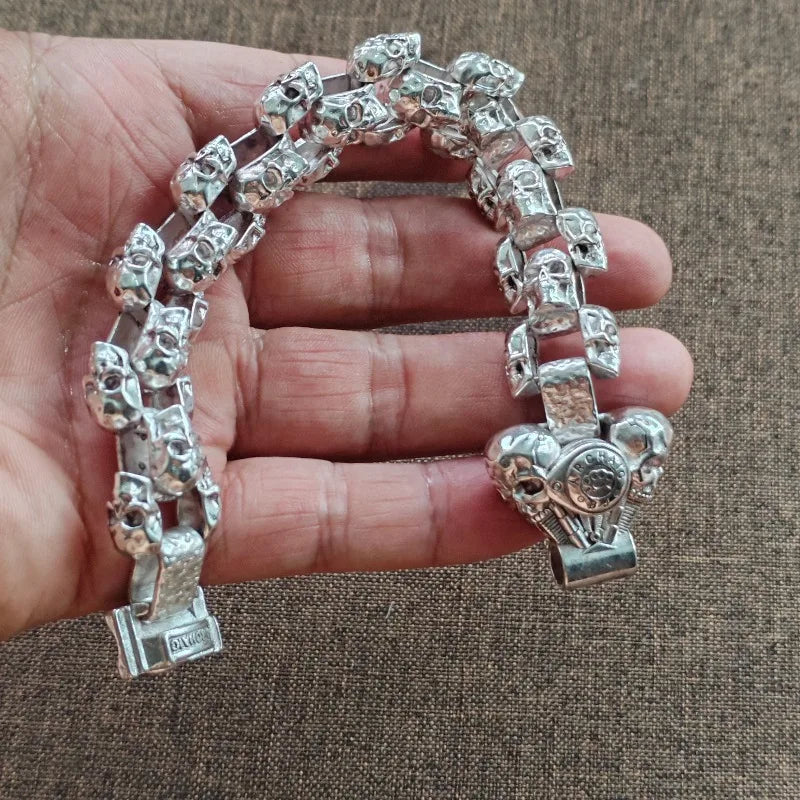 Vintage silberner Schädelarmband für Männer auf der Hand vor braunem Stoffhintergrund