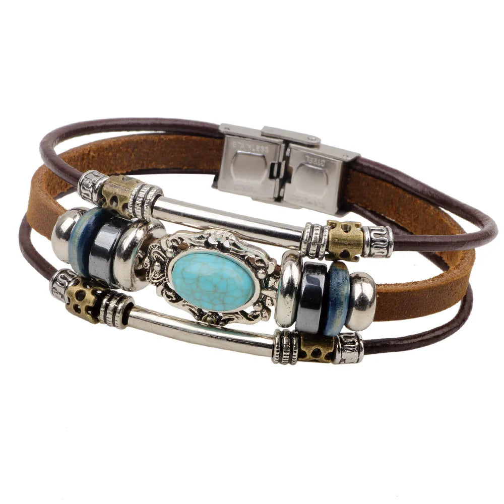 A brown leather bracelet featuring a silver compass design with blue and turquoise stones.