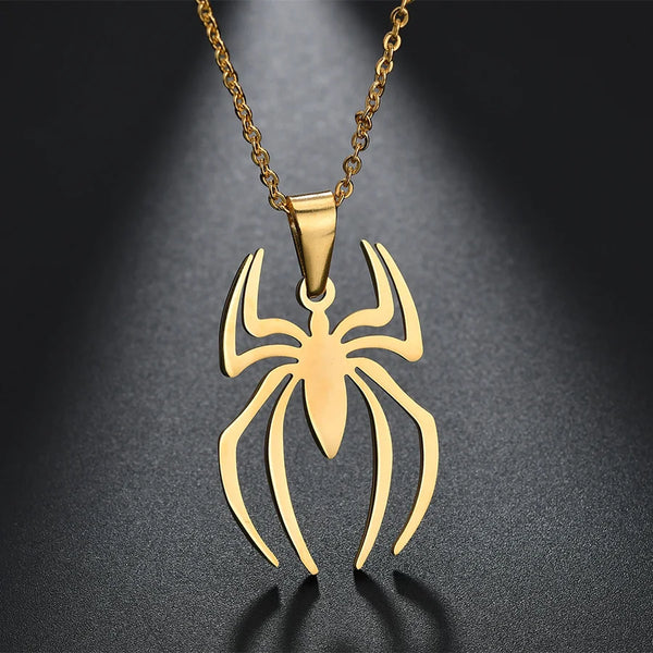 A gold-toned stainless steel spider pendant necklace displayed against a dark background.
