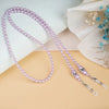 Two strands of light purple pearl beaded chains displayed on a beige surface next to white paper.
