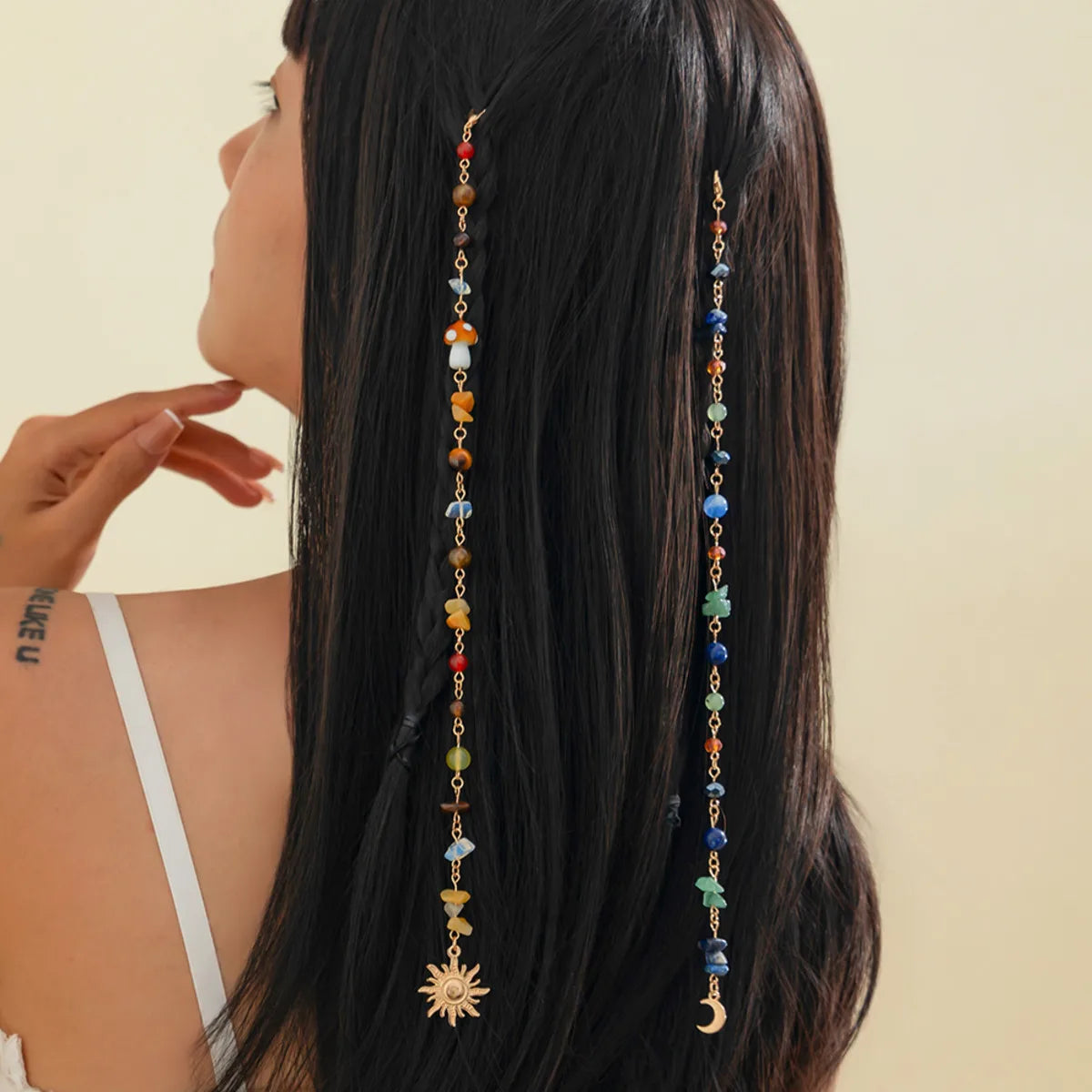 Long black hair adorned with a bohemian sun moon tassel hair headdress featuring colorful beads and charms