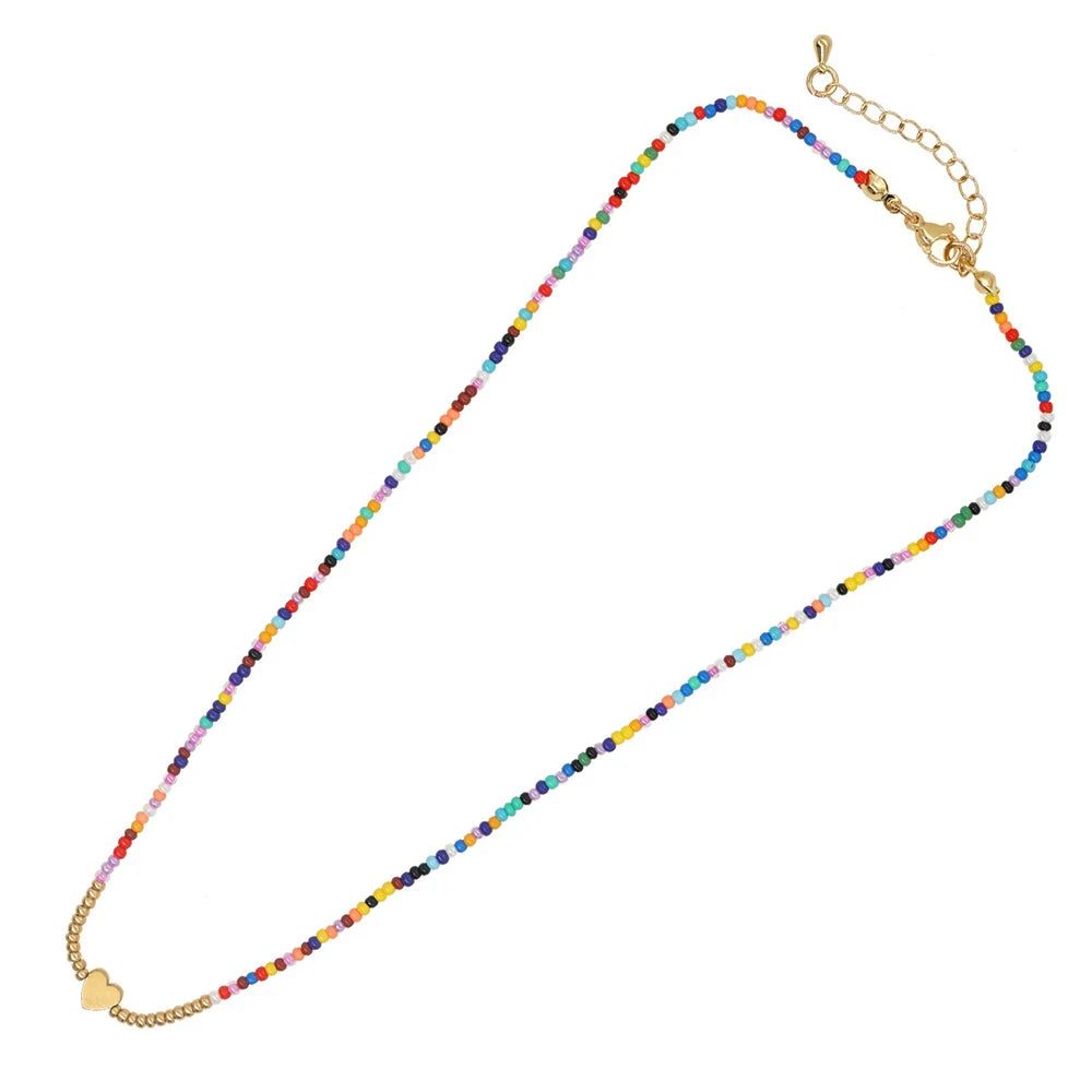 Langes Halsband mit farbenfrohen Perlen und goldener Kette, inklusive Anhänger in Herzform.