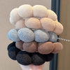 A stack of beige, gray, and brown cloud sponge hair accessories headbands