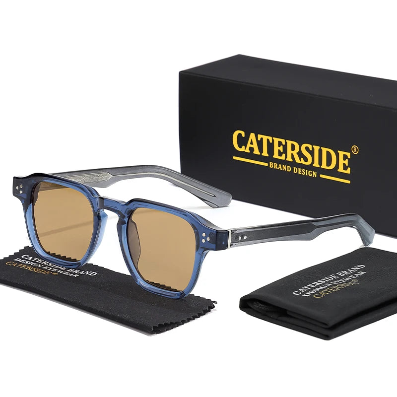 Eine blaue getönte, quadratische modische Sonnenbrille mit silbernem Rahmen, neben ihrer Box und einem gefalteten Tuch.