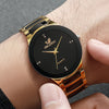 A close-up of a gold-toned analog quartz watch on a wrist, featuring a black face and gold accents.