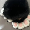 A pair of black and white cartoon cosplay furry gloves with soft fur texture.