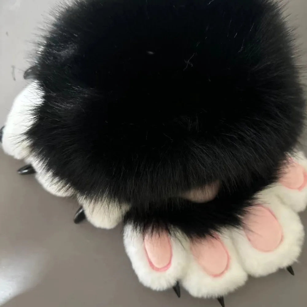 A pair of black and white cartoon cosplay furry gloves with soft fur texture.