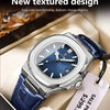 A silver-toned watch with a blue textured dial and blue leather strap is displayed in a box.