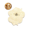 A gold-toned enamel pin and a round gold-toned metal piece are shown against a white background.