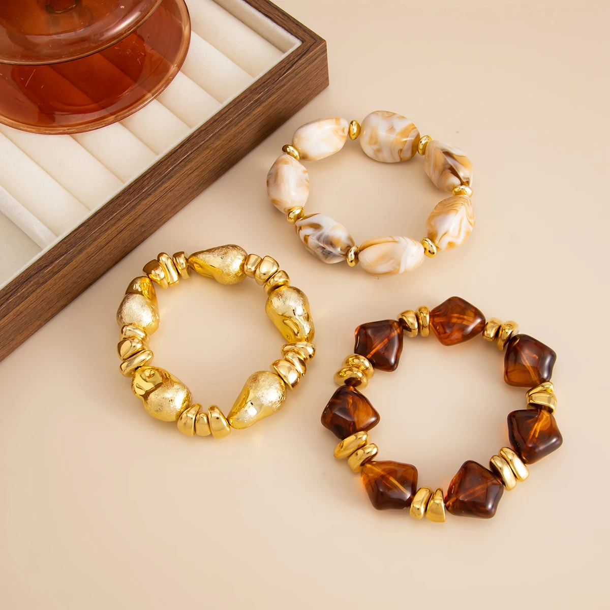 Un set de bracelets charm vintage en résine acrylique bohème avec perles de pierre naturelle et accents dorés.