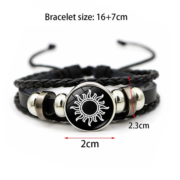 Black braided bracelet with a silver sun charm and black cord.