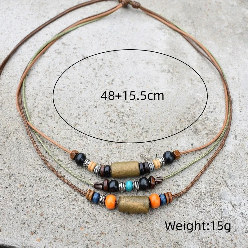 A set of boho vintage wood and stone bead necklaces laid on a gray surface.