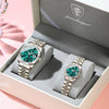 A pair of matching stainless steel watches with luminous hands and date display are displayed in a box.
