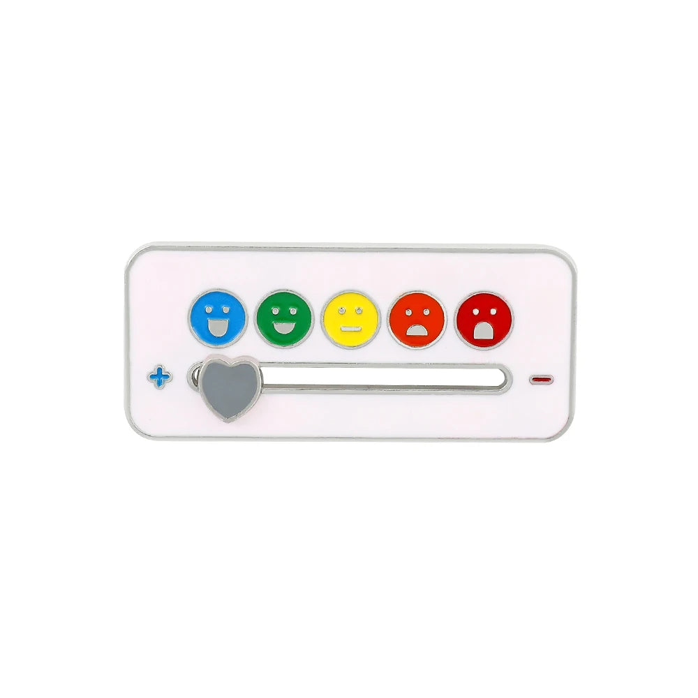 A white brooch pin featuring five colored smiley faces: blue, green, yellow, red, and a heart-shaped pin.