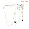 Gold chain necklace with butterfly pendants and round-framed glasses.
