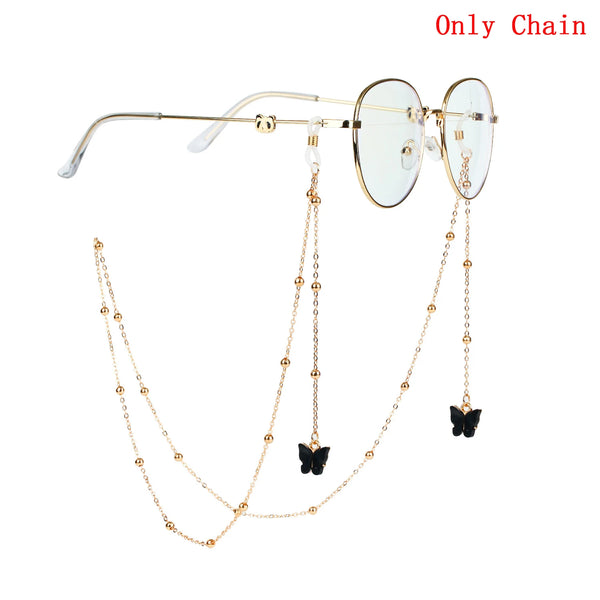 Gold chain necklace with butterfly pendants and round-framed glasses.