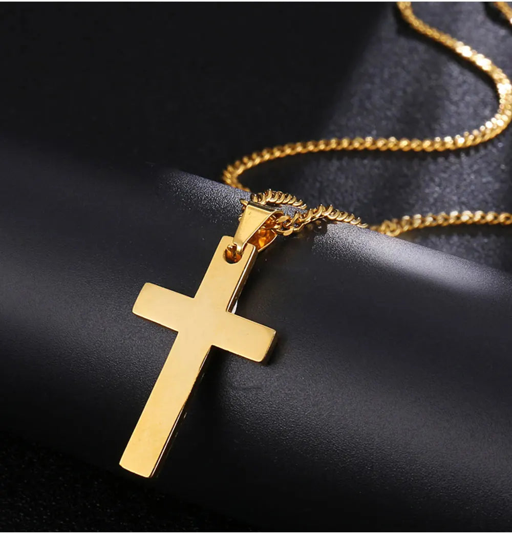 Goldene Edelstahlkreuz-Anhalskette auf dunkler Oberfläche.
