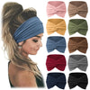 A collection of folded fabric headbands in various colors and patterns for yoga and sports.