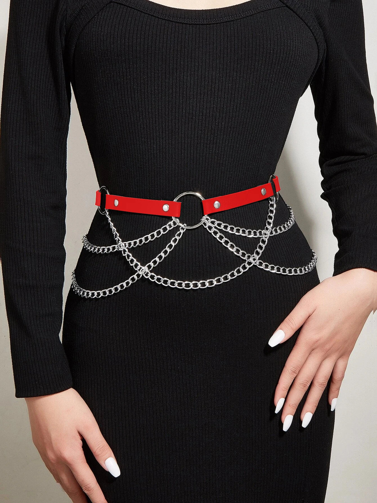 Vestido de rayas negras usado por una mujer con un cinturón de cuero falso rojo y cadenas plateadas