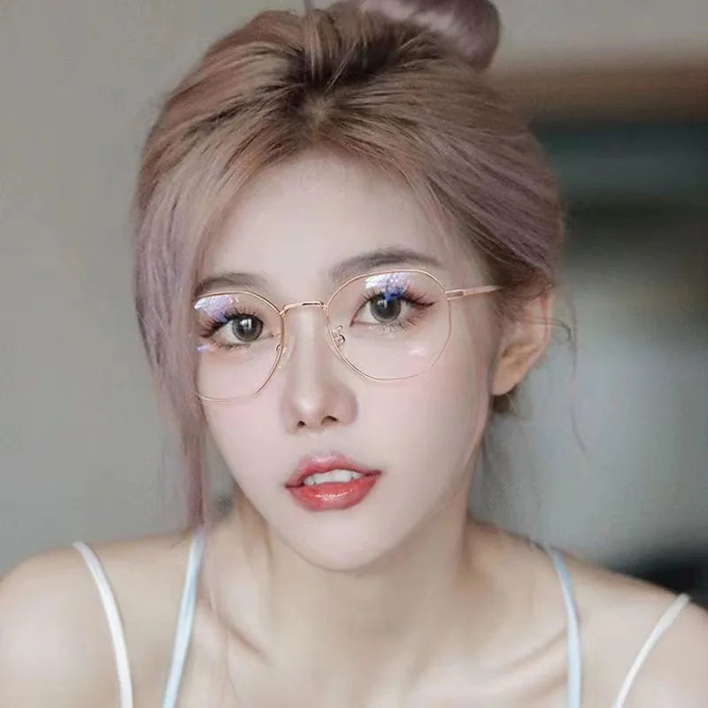 Gros plan d'une femme portant des lunettes anti-lumière bleue vintage à monture métallique fine.