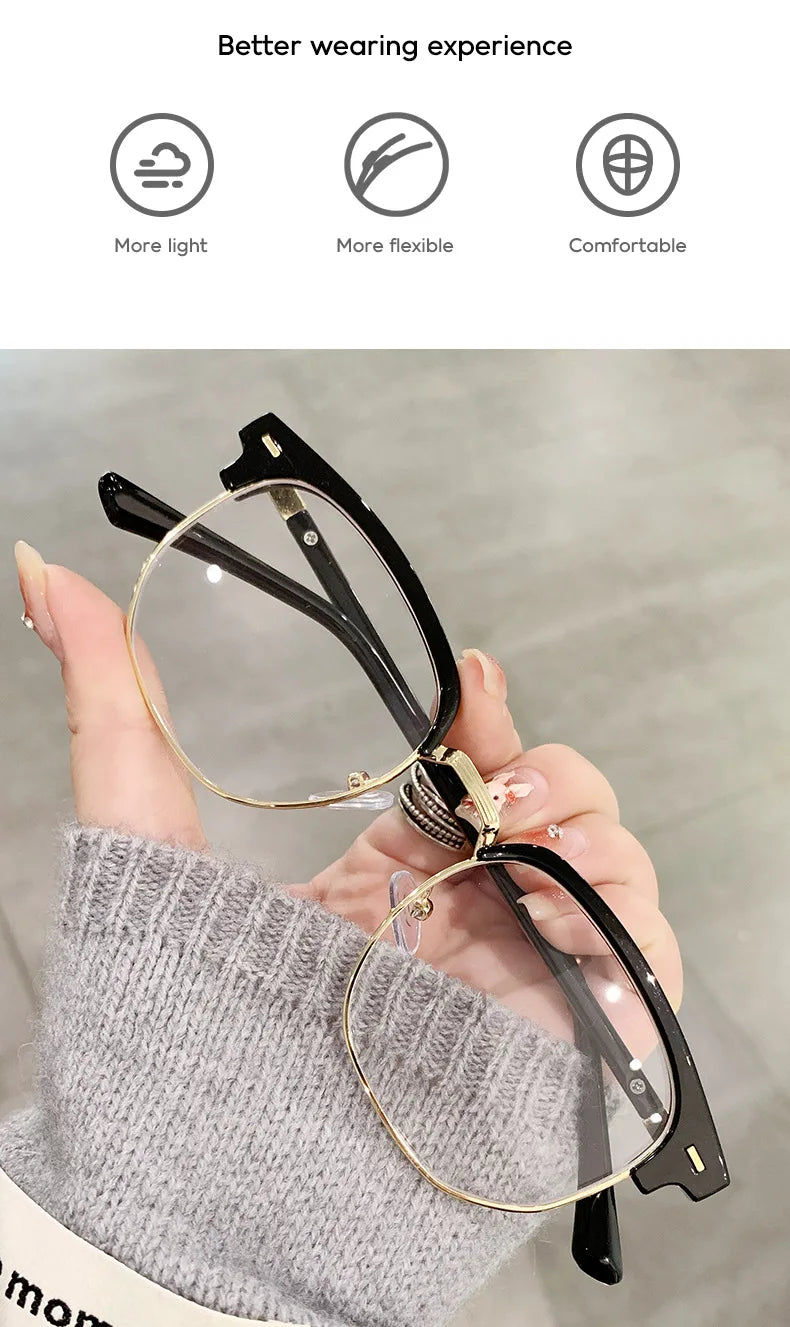 Une main tient des lunettes photochromiques noires anti-lumière bleue contre un pull gris tricoté.