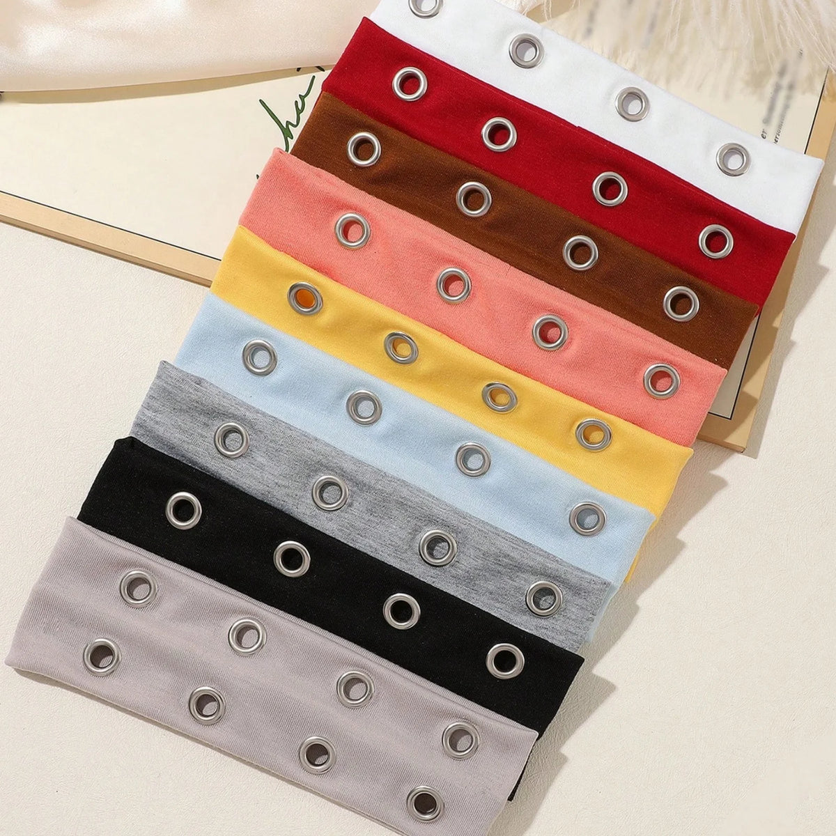 A stack of punk style metal hollow headbands in various colors including red, brown, pink, yellow, light blue, gray, and blac