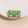 A green enamel dollar banknote brooch featuring an ocean shell charm.