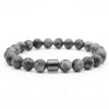 A bracelet made of polished grey and black tiger eye lava map beads.