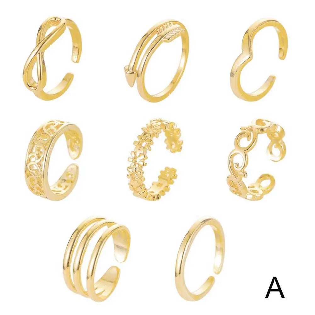 A set of gold adjustable open toe rings for women displayed against a white background.