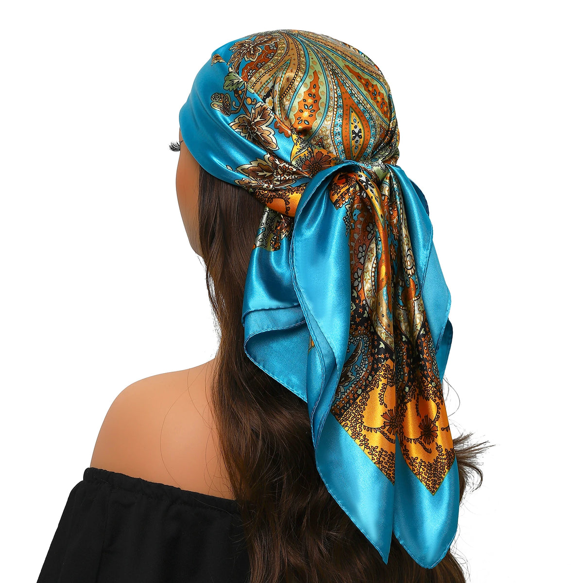 Eine Frau trägt ein blaues Seidernachse in orange-goldenem Paisley-Muster um ihr Haar gebunden.