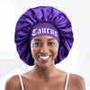 A woman wearing a purple satin sleep bonnet with a Taurus wrap band.