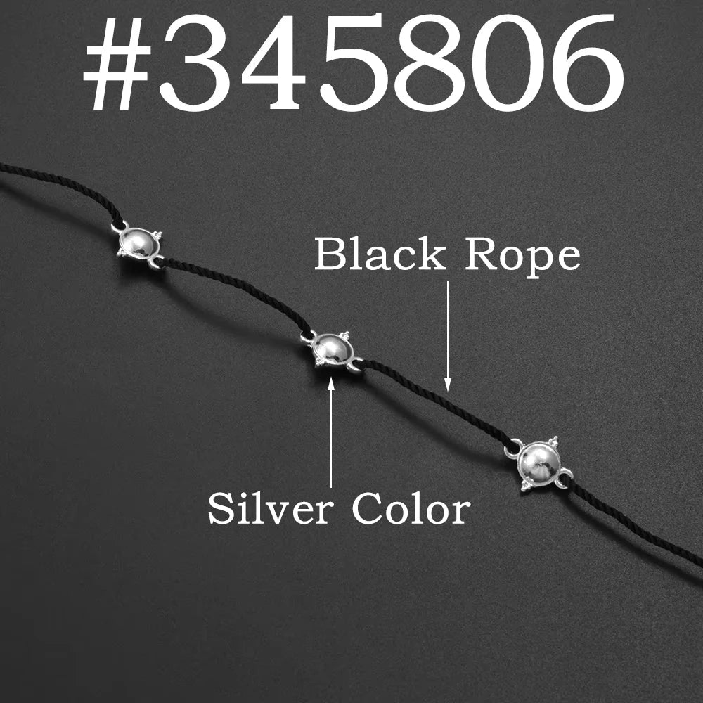 A black rope necklace with silver colored beads and a silver charm.