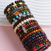 A stack of colorful fashion elastic wood bead bracelets featuring various shades of brown, green, blue, and white beads.