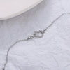 Sterling silver double heart charm bracelet displayed on white paper