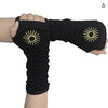 Black knitted fingerless gloves with golden sun designs worn on a hand.