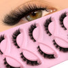 A pink cosmetic tray holding several pairs of black faux mink cat eye eyelashes.